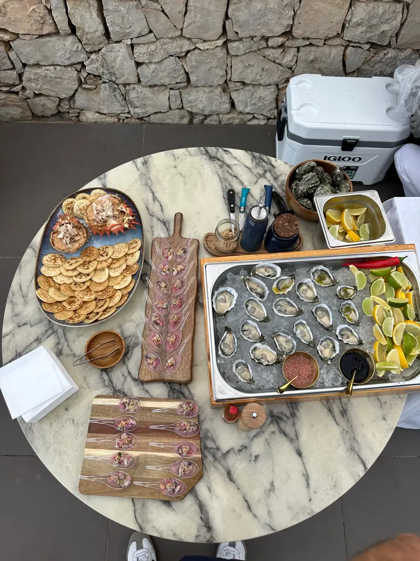 Mesa de mármore com ostras, tostas e petiscos num evento privado